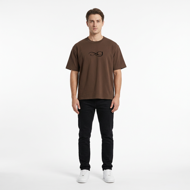 Model wearing the Gather Essential T-Shirt in brown on a white studio background