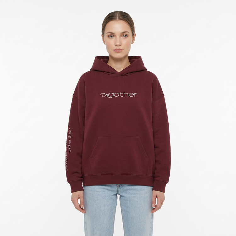 Model wearing the Gather Essential Hoodie in red on a white studio background